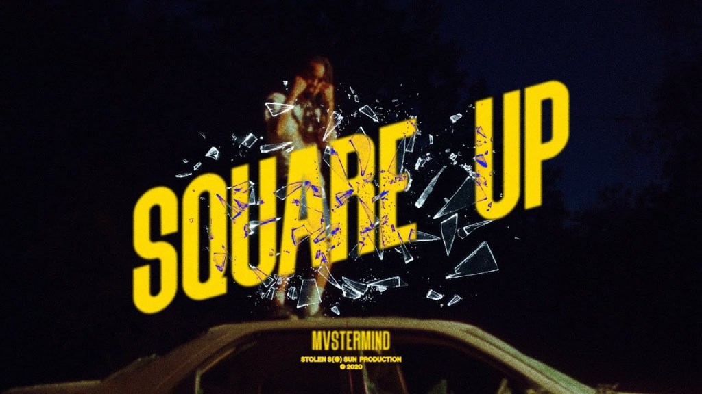 Cover art for Mvstermind's "Square Up" music video. Features bold yellow text that reads the title of the song and the artist with decorative broken glass. Behind the text, the artist has his fists up near his face and is standing on top of a car